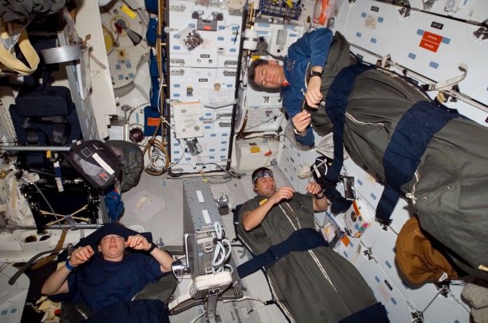 Astronauten in ihren Schlafsäcken im Space Shuttle Discovery (Bild: ESA)
